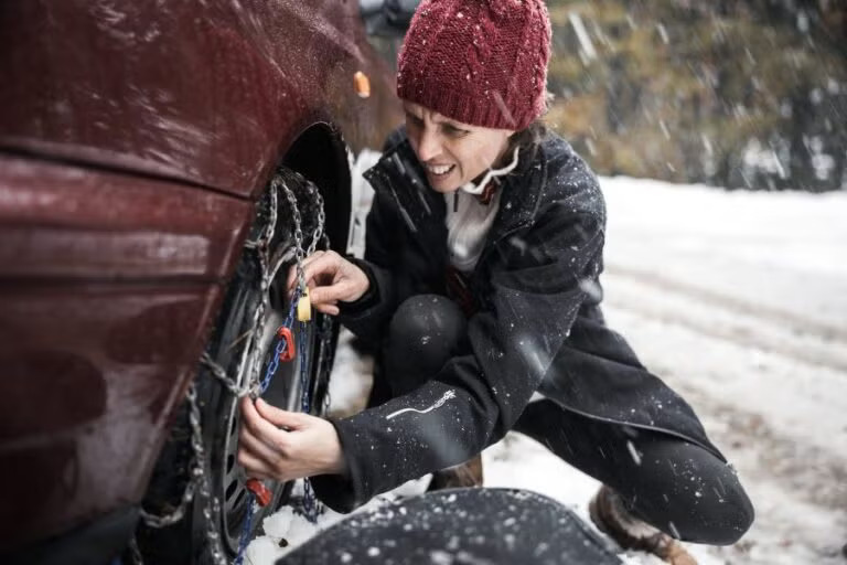 Women checking chains on tires
